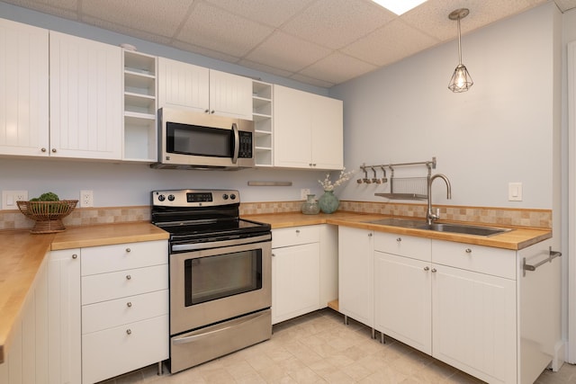 8562 W R Ave, Kalamazoo, MI 49009 - kitchen featuring appliances with stainless steel finishes, a sink, open shelves, butcher block countertops, and pendant lighting