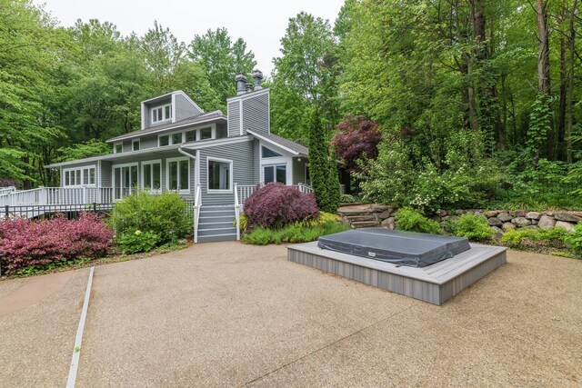 8562 W R Ave, Kalamazoo, MI 49009 - back of house with a chimney and a covered hot tub