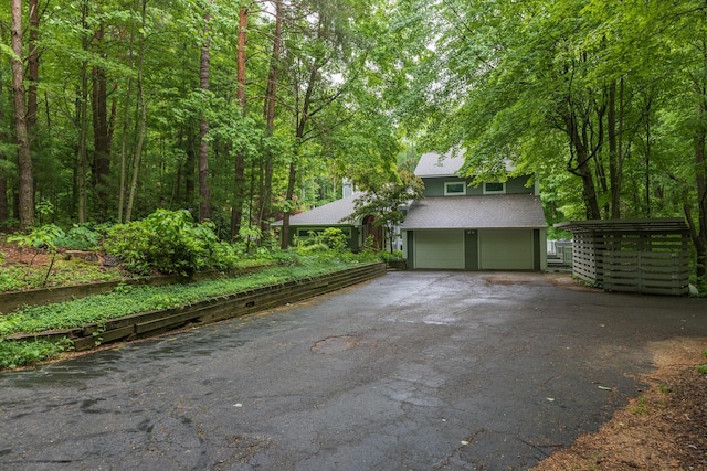 8562 W R Ave, Kalamazoo, MI 49009 - garage featuring asphalt driveway and a wooded view