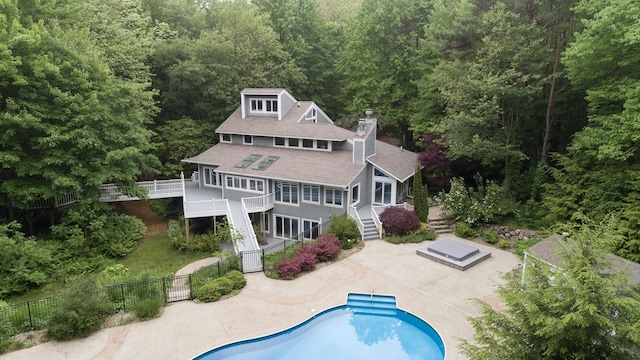 8562 W R Ave, Kalamazoo, MI 49009 - back of property featuring stairs, a forest view, a chimney, and roof with shingles