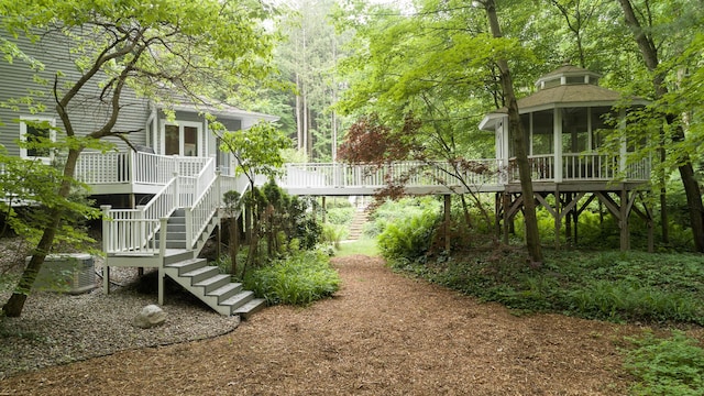 8562 W R Ave, Kalamazoo, MI 49009 - view of yard featuring stairway, a wooden deck, and a sunroom