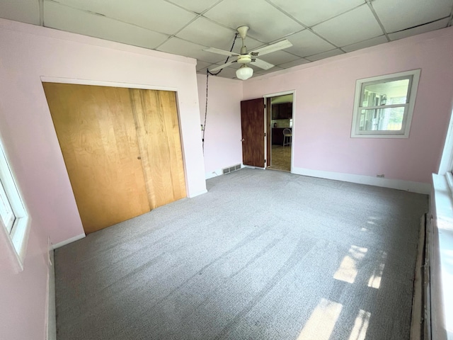 15522 Kimball Rd, Trufant, MI 49347 - unfurnished bedroom featuring a drop ceiling, carpet flooring, a closet, baseboards, and a ceiling fan