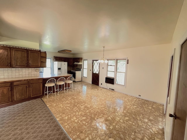 15522 Kimball Rd, Trufant, MI 49347 - kitchen featuring white appliances, a chandelier, healthy amount of natural light, and a peninsula