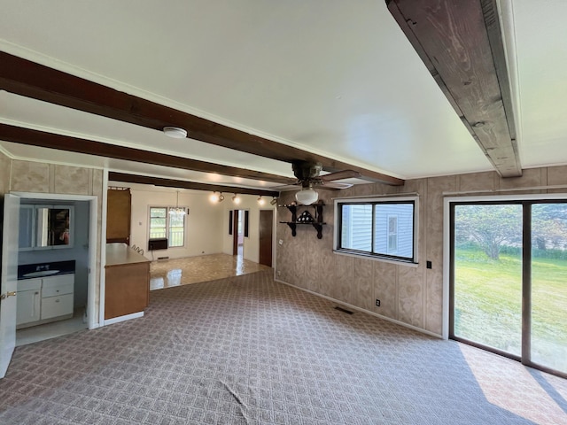 15522 Kimball Rd, Trufant, MI 49347 - unfurnished living room with beam ceiling, carpet floors, healthy amount of natural light, ceiling fan, and baseboards