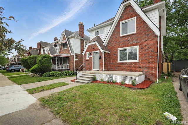 18287 Santa Rosa Dr, Dearborn, MI 48221 - tudor house featuring a front lawn, brick siding, and a chimney