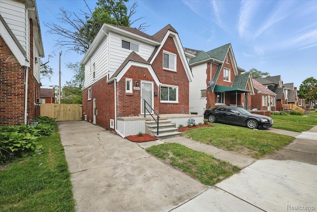 18287 Santa Rosa Dr, Dearborn, MI 48221 - tudor-style house with brick siding, driveway, a gate, and a residential view