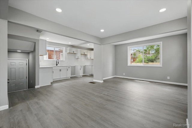 18287 Santa Rosa Dr, Dearborn, MI 48221 - unfurnished living room featuring a sink, healthy amount of natural light, wood finished floors, baseboards, and recessed lighting