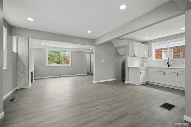 18287 Santa Rosa Dr, Dearborn, MI 48221 - unfurnished living room with a sink, plenty of natural light, baseboards, recessed lighting, and light wood finished floors