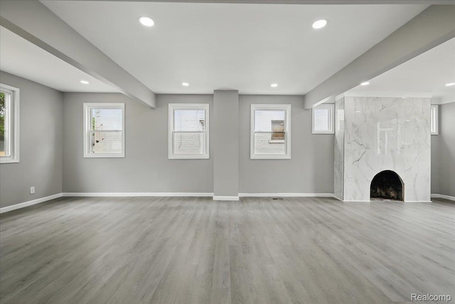 18287 Santa Rosa Dr, Dearborn, MI 48221 - unfurnished living room featuring baseboards, light wood-style flooring, healthy amount of natural light, recessed lighting, and a premium fireplace