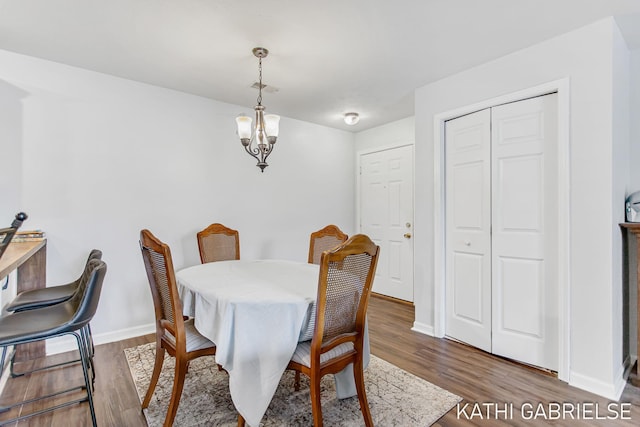 5869 Crosswinds Dr Unit 21, Norton Shores, MI 49444 - dining room featuring wood finished floors, baseboards, and a chandelier