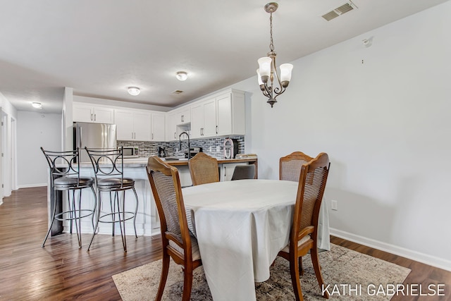 5869 Crosswinds Dr Unit 21, Norton Shores, MI 49444 - dining room with dark wood-type flooring, a chandelier, and baseboards