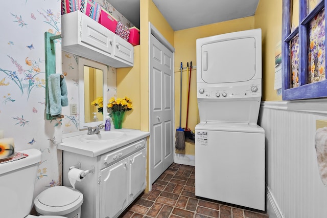 122 N Robinson St, Schoolcraft, MI 49087 - laundry room with estacked washer and dryer, brick patterned flooring, and a wainscoted wall