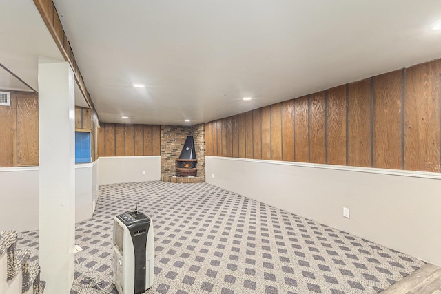 488 Roberts St, Muskegon, MI 49442 - finished basement featuring wooden walls, recessed lighting, a wood stove, and carpet flooring