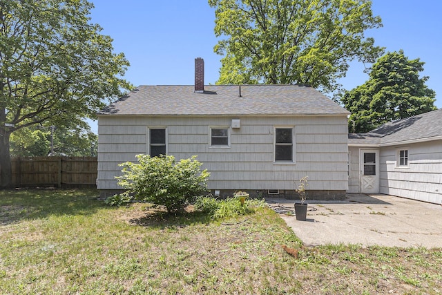488 Roberts St, Muskegon, MI 49442 - back of house featuring a chimney, a patio, and roof with shingles