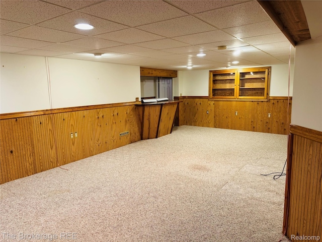 2525 Torrey Grove Ct, Fenton, MI 48430 - carpeted spare room featuring wainscoting, wooden walls, a drop ceiling, and bar
