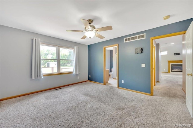 38 Melvin J Ct, Oxford, MI 48371 - unfurnished bedroom with baseboards, carpet, a glass covered fireplace, ensuite bath, and ceiling fan