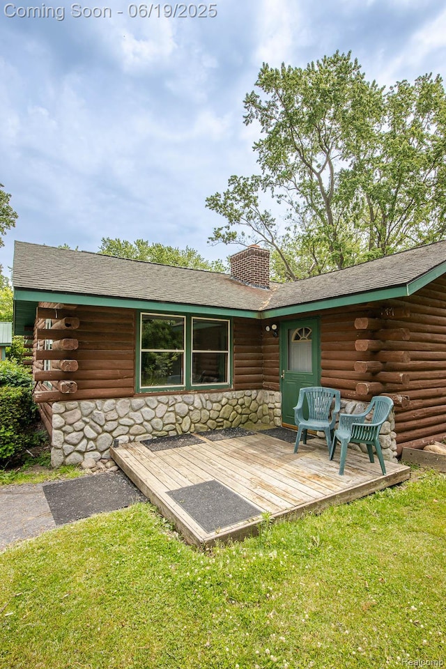 5180 Hillsboro Rd, Davisburg, MI 48350 - back of house with log siding, stone siding, a chimney, a yard, and a wooden deck