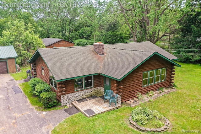 5180 Hillsboro Rd, Davisburg, MI 48350 - log cabin featuring log exterior, a front lawn, a shingled roof, a chimney, and an outdoor structure