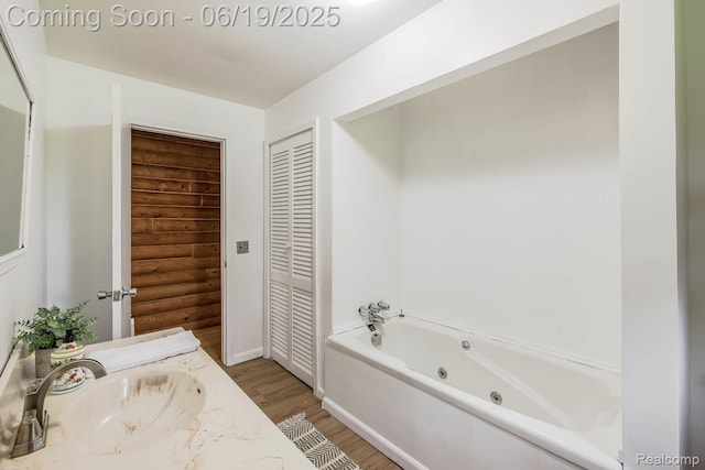 5180 Hillsboro Rd, Davisburg, MI 48350 - bathroom featuring a tub with jets, wood finished floors, and vanity