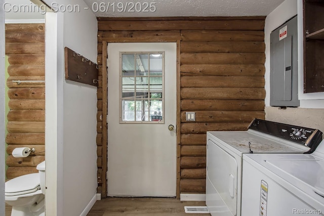 5180 Hillsboro Rd, Davisburg, MI 48350 - washroom featuring log walls, electric panel, separate washer and dryer, and light wood-style floors
