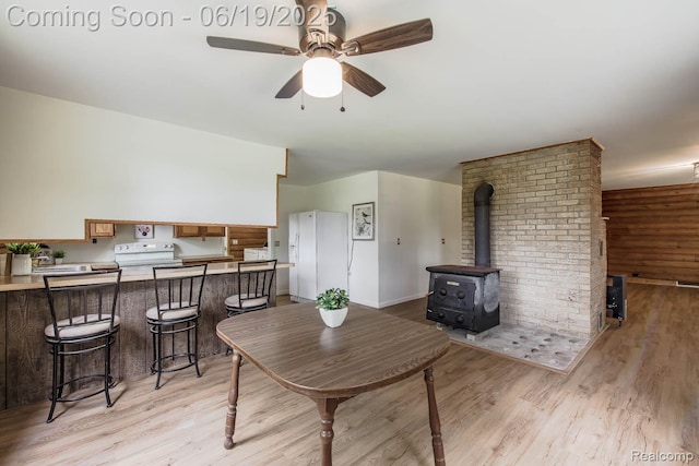 5180 Hillsboro Rd, Davisburg, MI 48350 - dining space featuring light wood-type flooring, a wood stove, and a ceiling fan