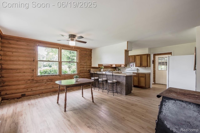 5180 Hillsboro Rd, Davisburg, MI 48350 - dining area featuring log walls, ceiling fan, and light wood-type flooring