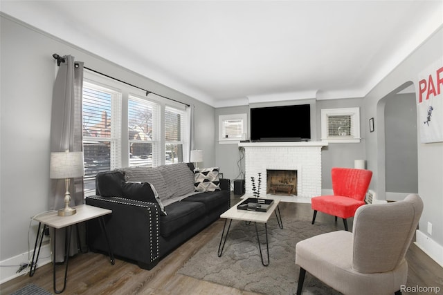 13572 Indiana St, Detroit, MI 48238 - living room featuring wood finished floors, a brick fireplace, baseboards, and arched walkways