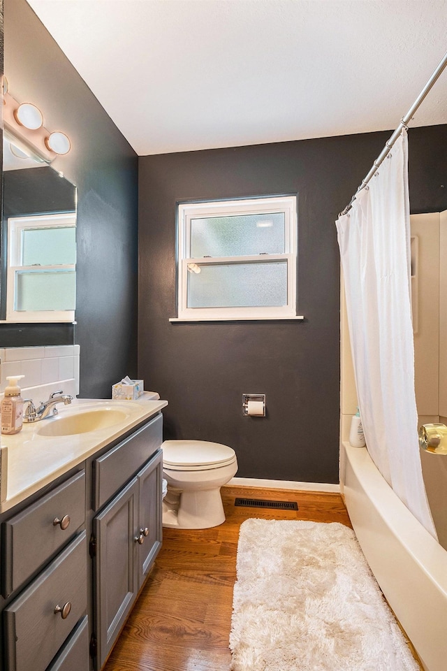 4292 Ashlawn Dr, Flint, MI 48507 - full bath featuring vanity, toilet, wood finished floors, shower / bath combo with shower curtain, and decorative backsplash