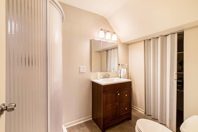 4292 Ashlawn Dr, Flint, MI 48507 - bathroom featuring toilet, vanity, tile patterned flooring, vaulted ceiling, and baseboards