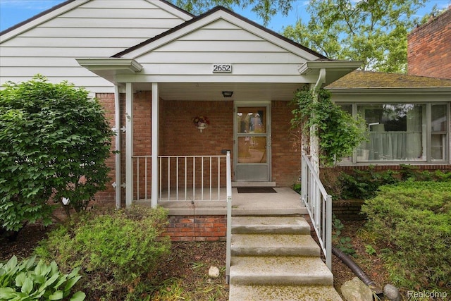 2652 Buckingham Ave, Berkley, MI 48072 - view of exterior entry featuring brick siding, covered porch, and a chimney