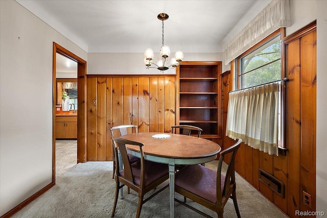 2652 Buckingham Ave, Berkley, MI 48072 - carpeted dining space featuring a chandelier and wood walls