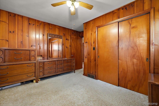 2652 Buckingham Ave, Berkley, MI 48072 - bedroom with light carpet, wood walls, a closet, and a ceiling fan