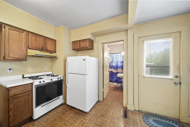 2016 Pringle Ave, Jackson, MI 49203 - kitchen featuring white appliances, under cabinet range hood, brick patterned floors, brown cabinets, and light countertops