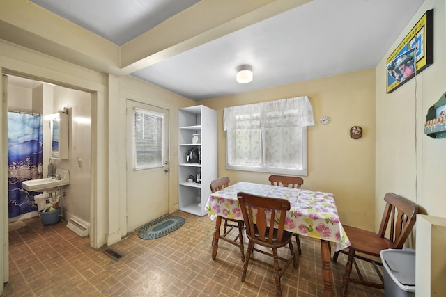 2016 Pringle Ave, Jackson, MI 49203 - dining space featuring plenty of natural light, brick patterned flooring, and baseboard heating