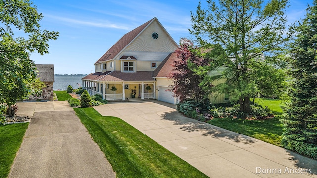 12571 Westwood Ln, Wayland, MI 49348 - victorian home featuring covered porch, concrete driveway, a front lawn, a garage, and a water view