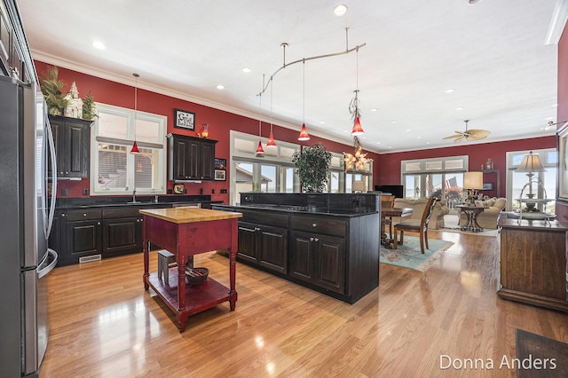 12571 Westwood Ln, Wayland, MI 49348 - kitchen featuring wooden counters, freestanding refrigerator, open floor plan, light wood-style flooring, and crown molding