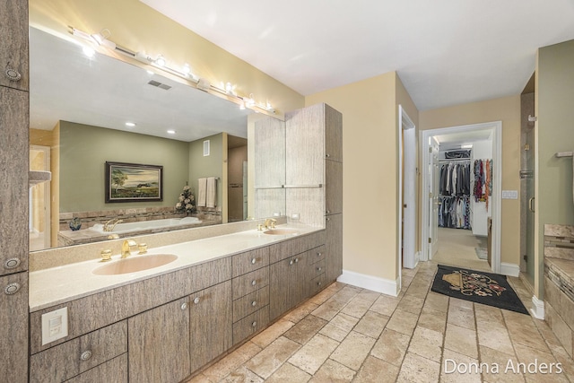 12571 Westwood Ln, Wayland, MI 49348 - full bathroom with a bath, stone tile floors, a walk in closet, and double vanity