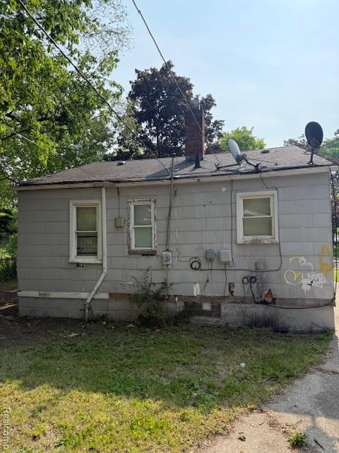 19495 Lindsay St, Detroit, MI 48235 - view of front of property with a front lawn, a chimney, and roof with shingles