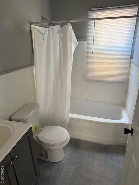 19495 Lindsay St, Detroit, MI 48235 - bathroom featuring tile walls, wood finished floors, toilet, vanity, and shower / bath combination with curtain