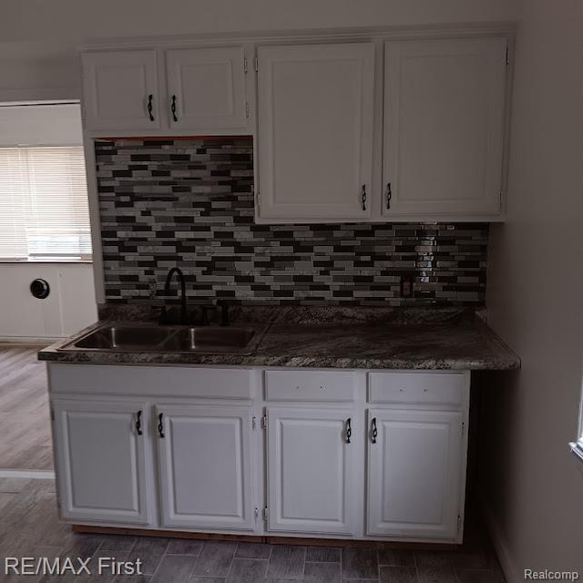 13500 Heyden St, Detroit, MI 48223 - kitchen with a sink, white cabinetry, dark countertops, and backsplash
