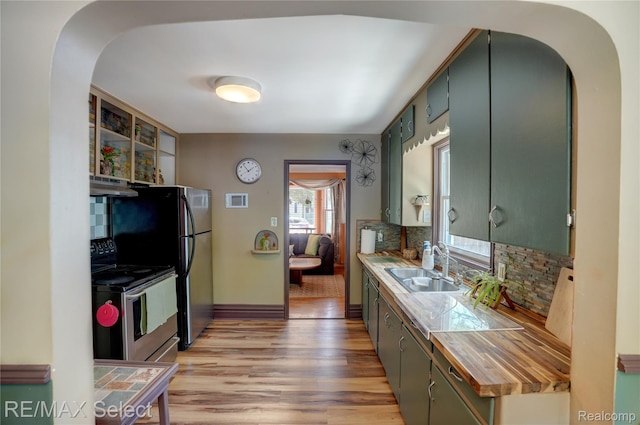 3418 Gratiot Ave, Flint, MI 48503 - kitchen featuring under cabinet range hood, electric stove, arched walkways, and light wood finished floors