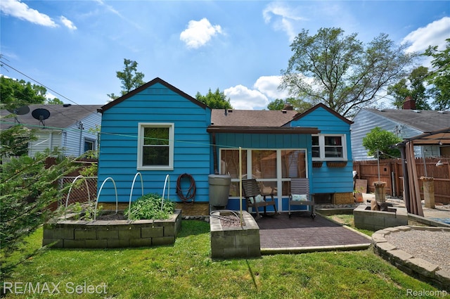 3418 Gratiot Ave, Flint, MI 48503 - rear view of house featuring a patio, a shingled roof, and a fire pit