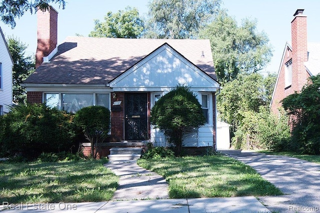 8035 Pinehurst St, Detroit, MI 48204 - english style home featuring a front yard, roof with shingles, and a chimney