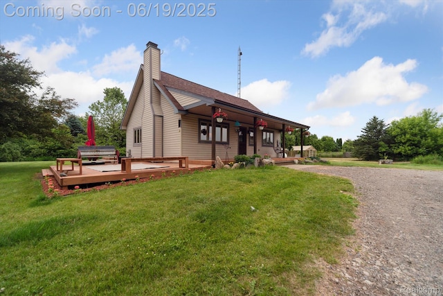 9808 Crofoot Rd, Fowlerville, MI 48836 - view of front facade featuring a front lawn, covered porch, a chimney, and a deck