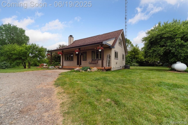 9808 Crofoot Rd, Fowlerville, MI 48836 - view of front facade with covered porch, a chimney, and a front yard