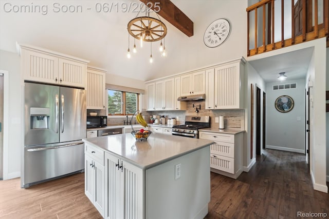 9808 Crofoot Rd, Fowlerville, MI 48836 - kitchen featuring stainless steel appliances, backsplash, under cabinet range hood, dark wood-style flooring, and beamed ceiling