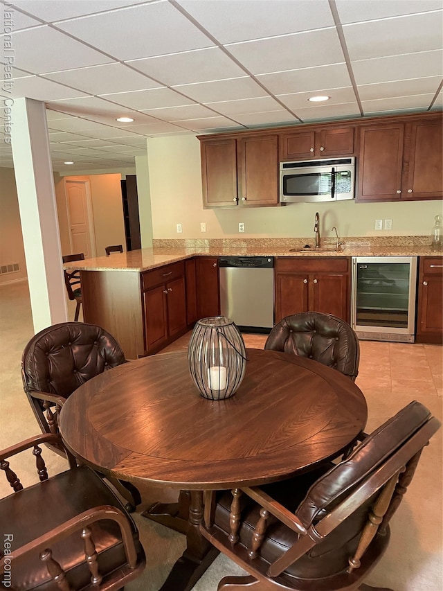 2750 Castlemartin Ct, Oakland, MI 48306 - kitchen with stainless steel appliances, wine cooler, a sink, a peninsula, and a paneled ceiling