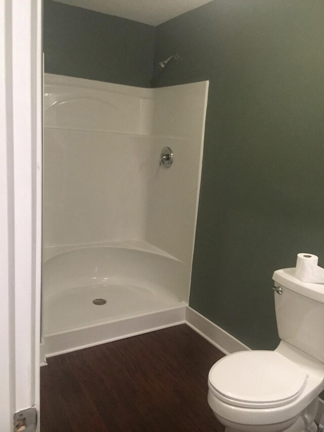 1116 Covell Ave NW, Grand Rapids, MI 49504 - bathroom with a shower, toilet, wood finished floors, and baseboards