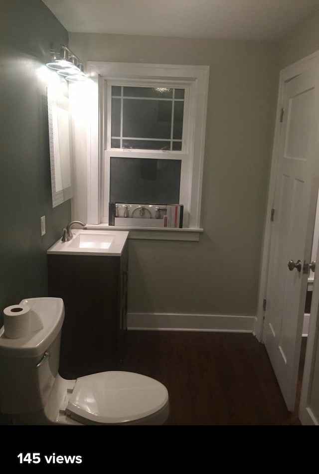 1116 Covell Ave NW, Grand Rapids, MI 49504 - bathroom featuring vanity, toilet, wood finished floors, and baseboards