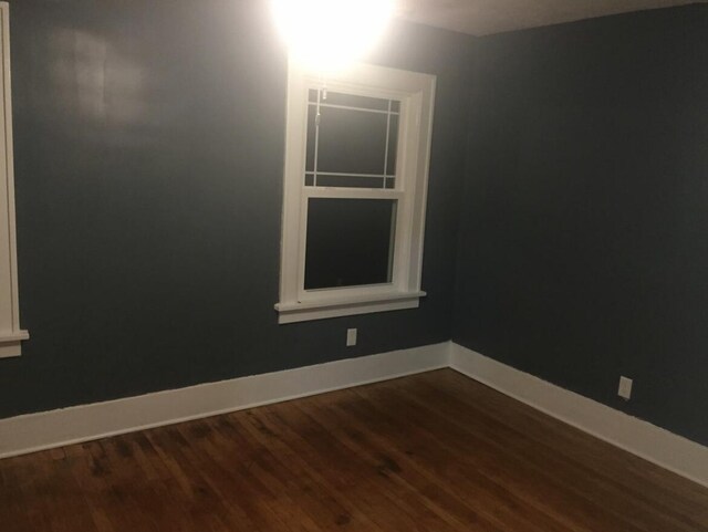1116 Covell Ave NW, Grand Rapids, MI 49504 - spare room featuring dark wood-style flooring and baseboards